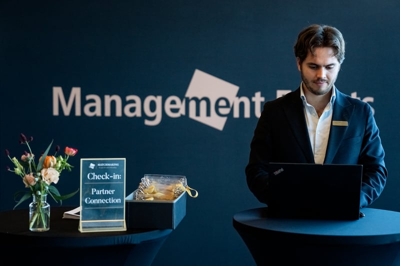 Employee at executive event registration desk - ready to check in solution providers